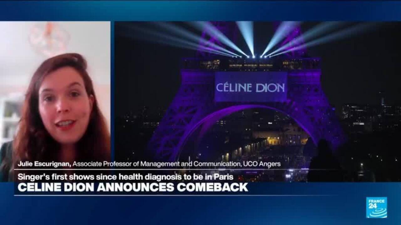 Celine Dion performing on stage with the illuminated Eiffel Tower visible in background