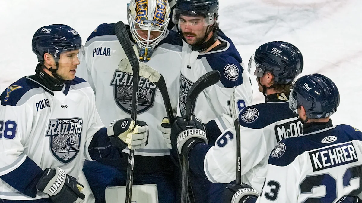 Worcester Railers players celebrating together on ice after winning historic 1,000th game at DCU Center