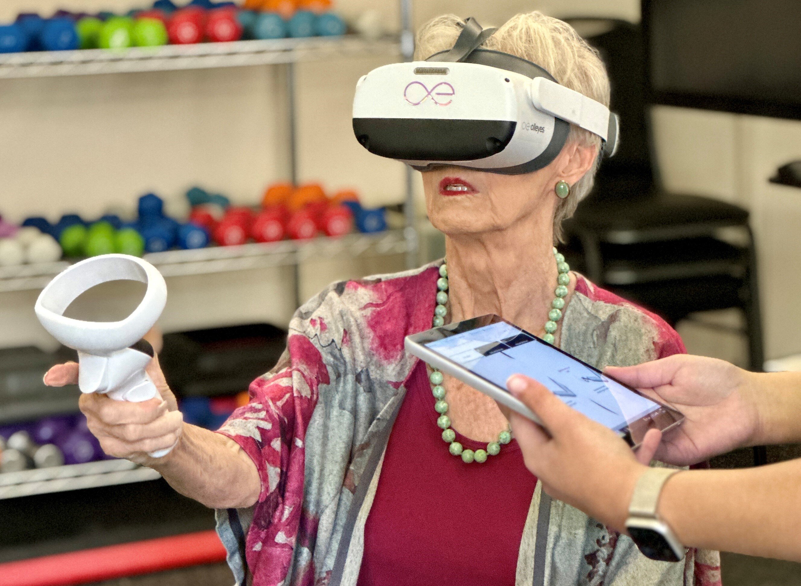 Senior woman wearing virtual reality headset during eye exam in assisted living recreation room