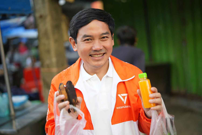 Dr. Supat Hasuwannakit speaking at podium as People's Party candidate in Thailand