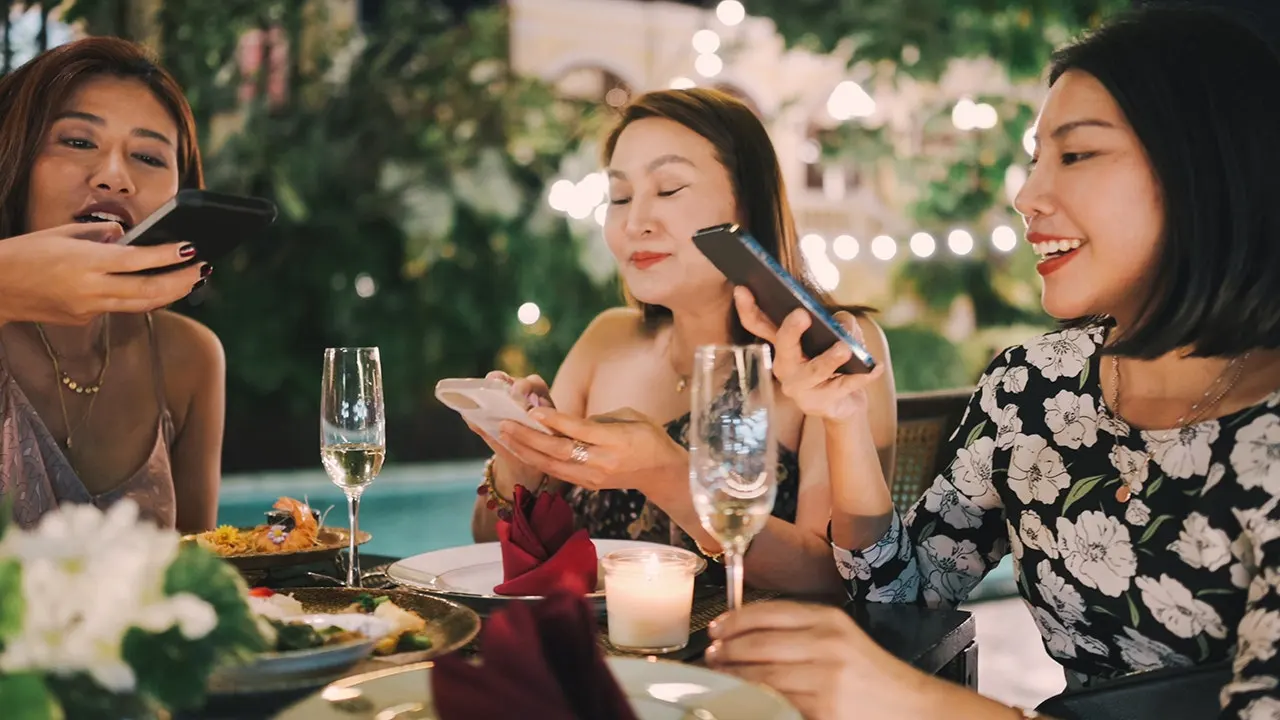 Friends enjoying dinner conversation together at restaurant table without phones