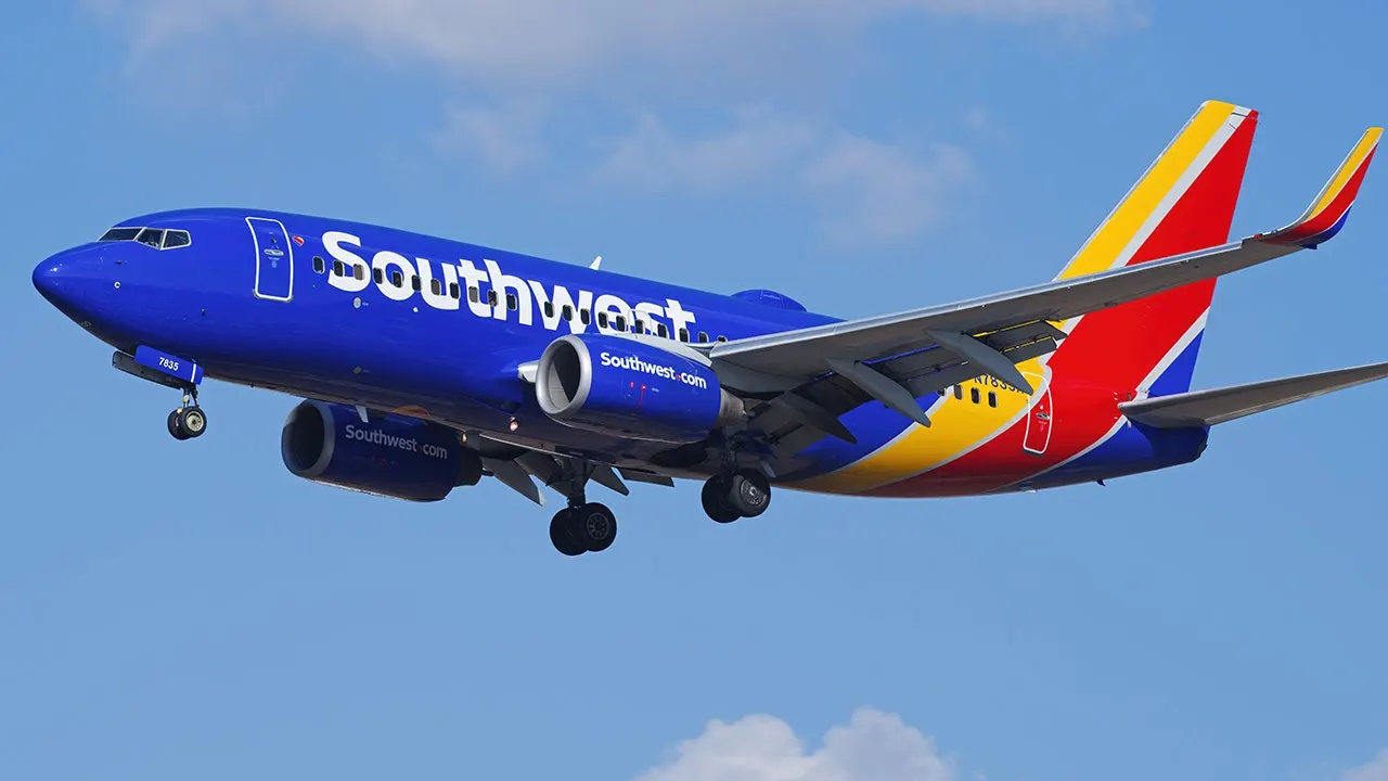 Southwest Airlines captain and his daughter first officer standing together in cockpit celebrating retirement flight
