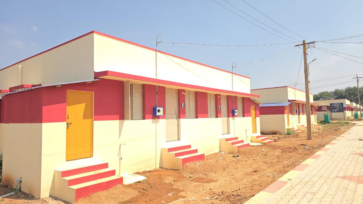 Rows of small single-story homes with red tile roofs in new refugee housing development India