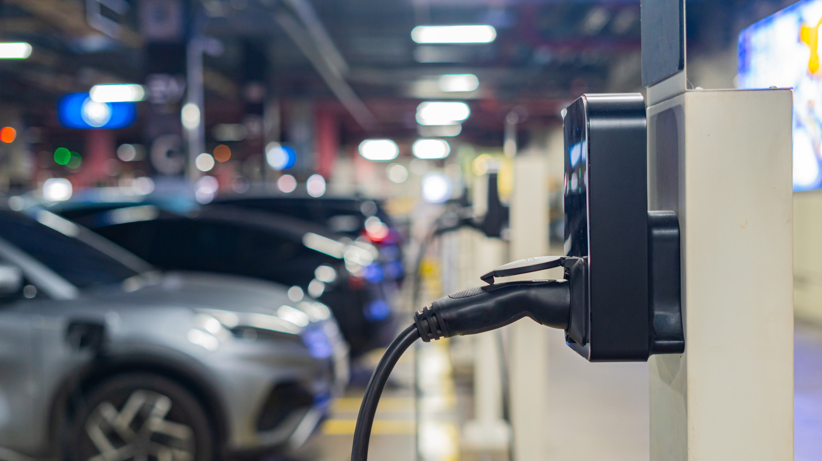 Electric vehicle charging at highway station during road trip with charging cable connected