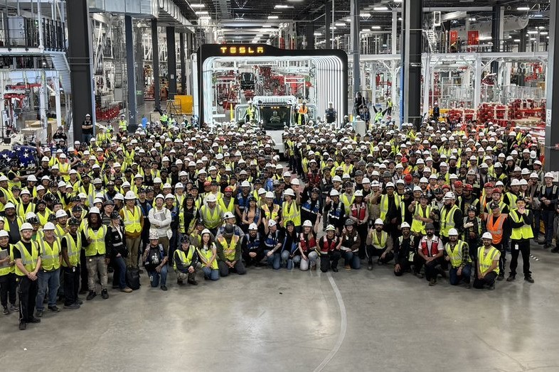 First mass-produced Tesla Semi electric truck on factory floor surrounded by workers at Nevada Gigafactory