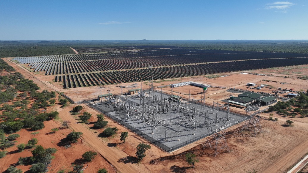 Solar panels installed on rooftops across African community under bright blue sky
