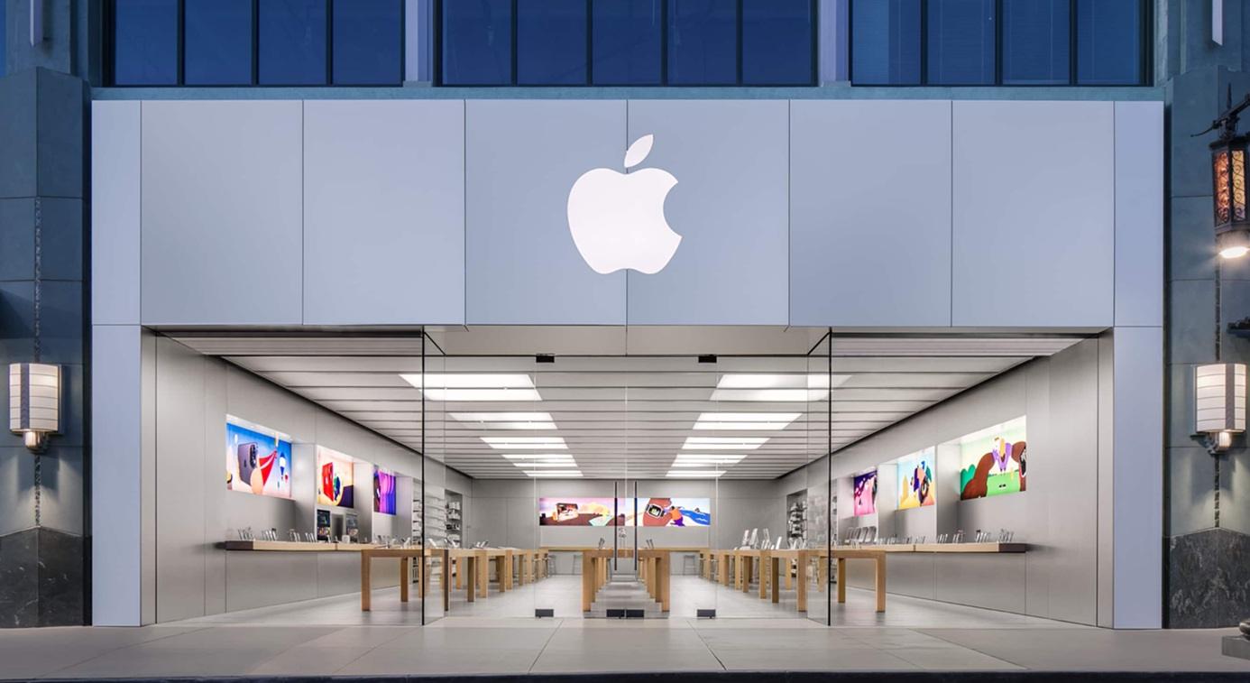 Solar panels and wind turbines powering manufacturing facility with Apple logo visible