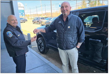** Ford F-150 Lightning electric pickup truck in police livery parked at station