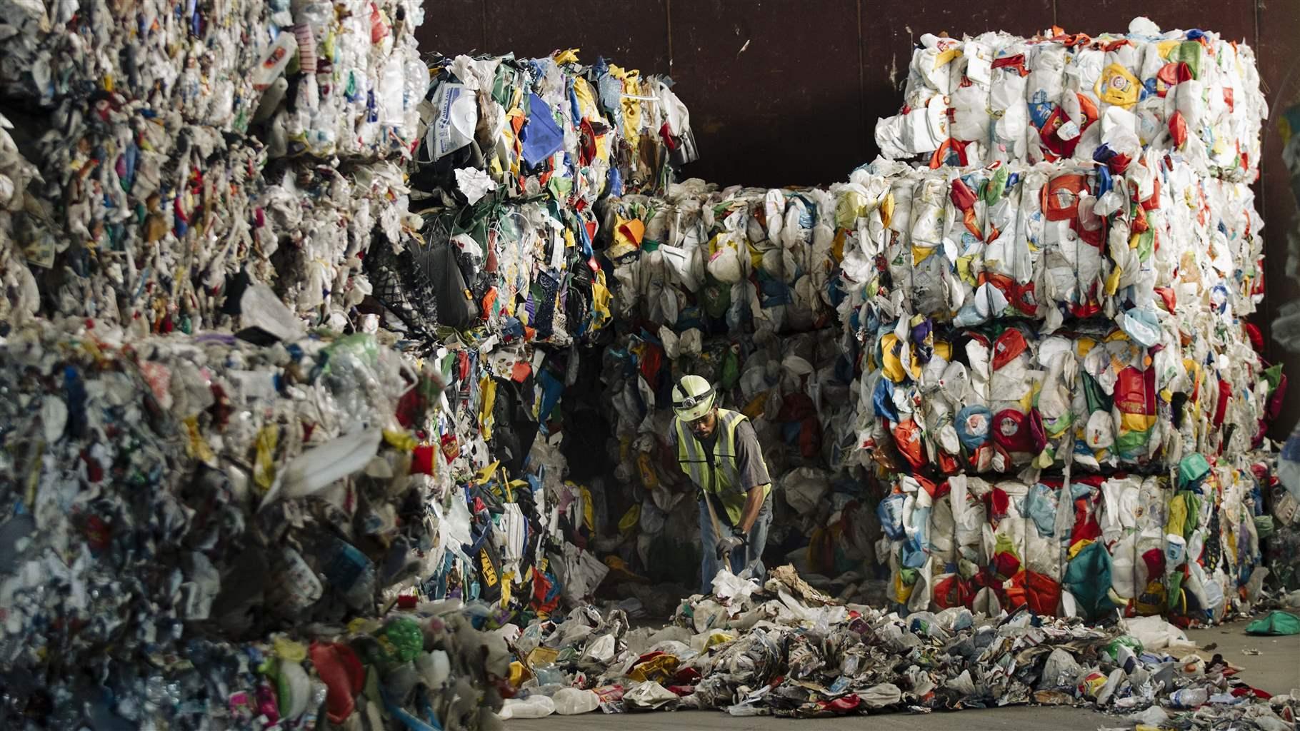 Worker at recycling facility organizing plastic materials for processing and reuse
