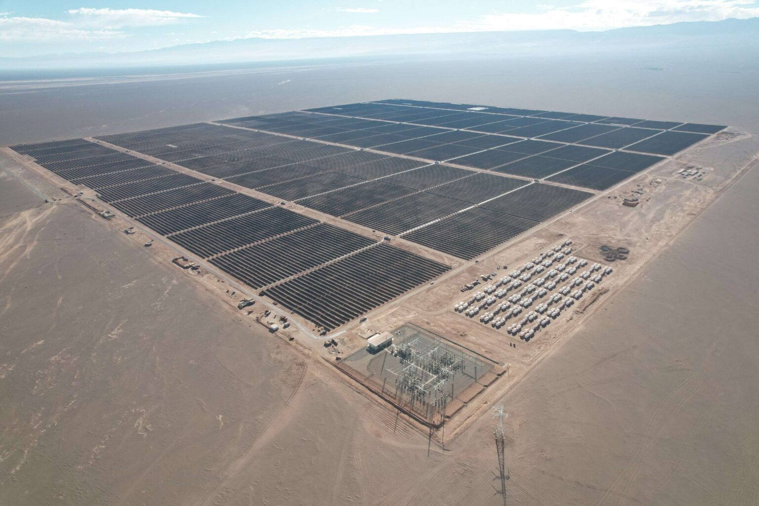 Rows of solar panels stretching across Chile's sunny landscape under blue sky
