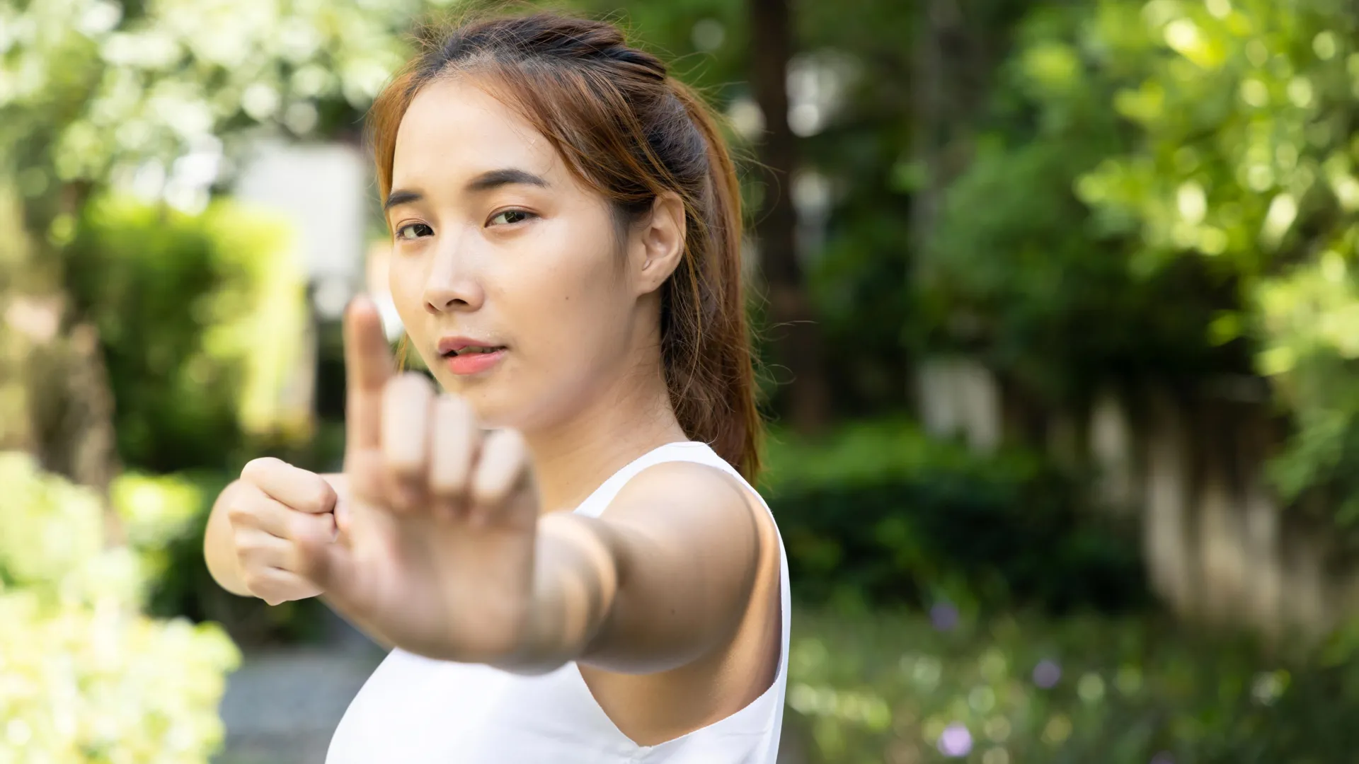 Group of adults practicing gentle baduanjin movements outdoors in community setting