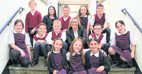 Four Pope John XXIII graduates in caps and gowns celebrating during school liturgy ceremony