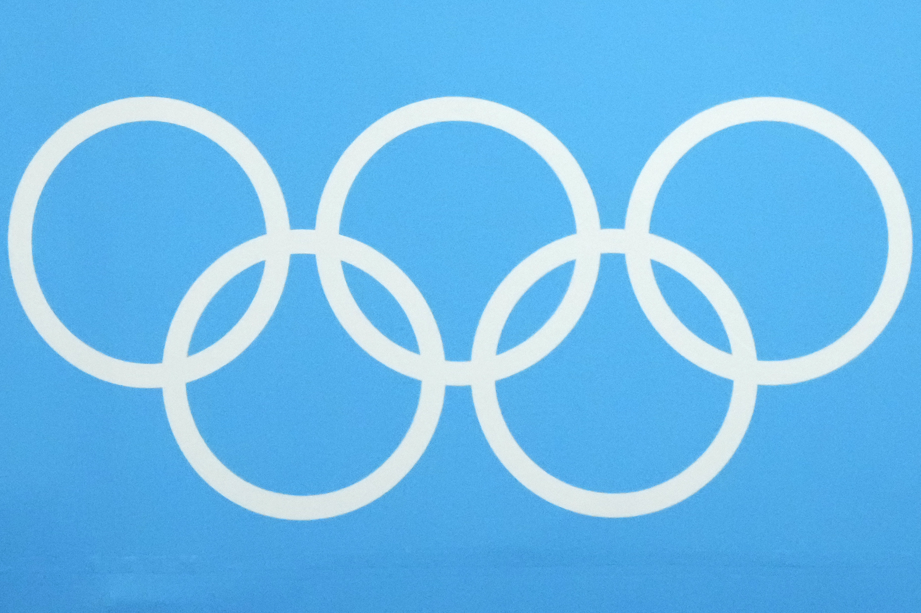 ** Olympic rings displayed at Winter Games venue with snow-covered mountains in background